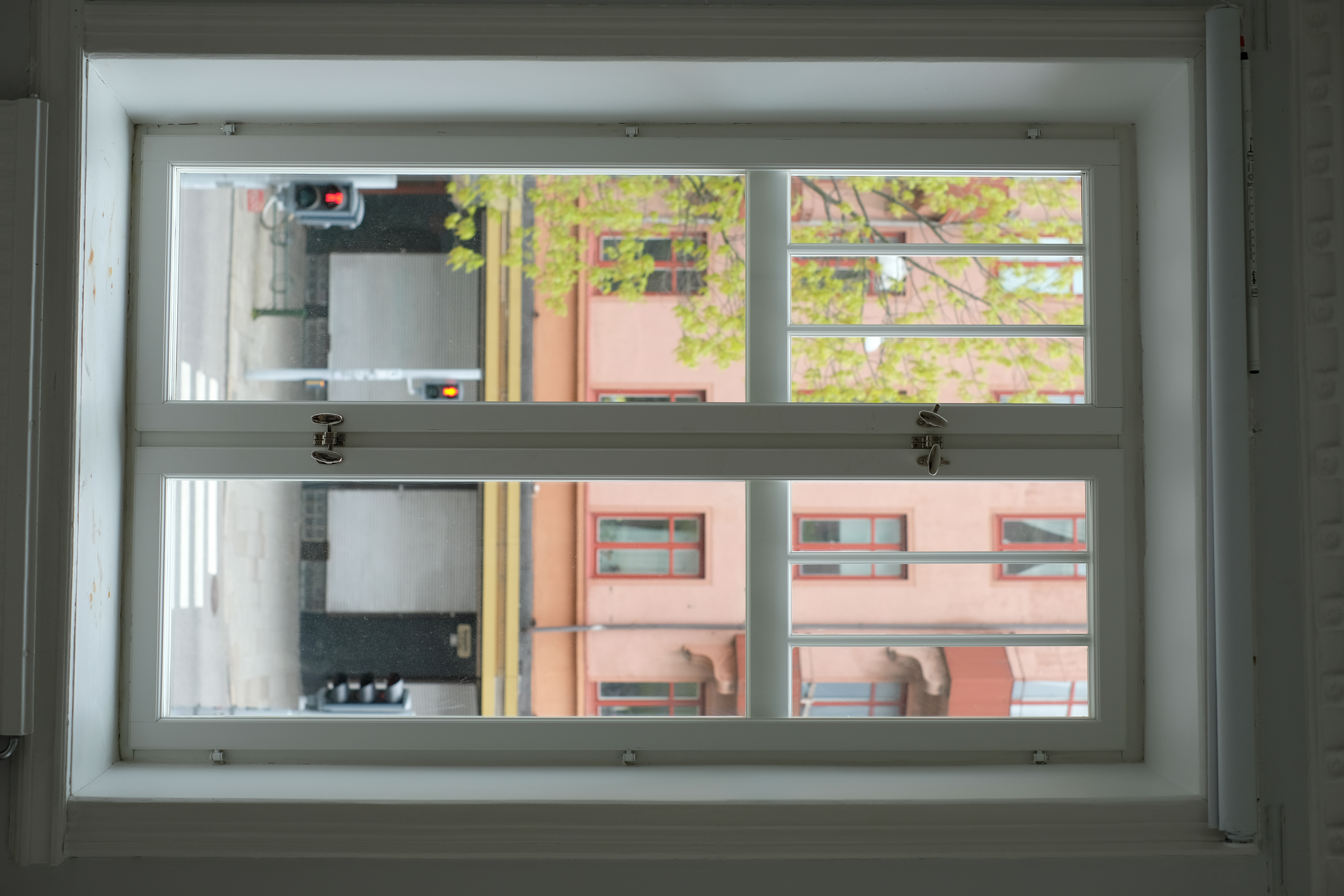 Bild inifrån på fönster med tidstypiska spröjs och låsanordning